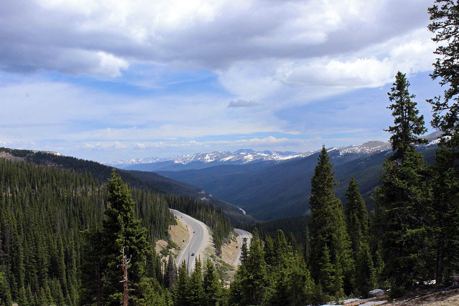 A paved road winding through a forested mountain pass